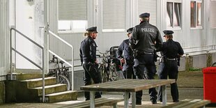 Polizisten vor Wohncontainer