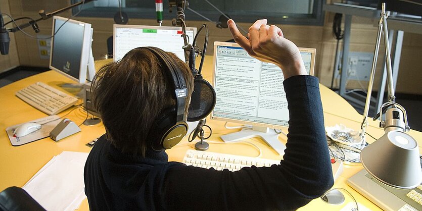 Eine Person sitzt in einem Aufnahmestudio.