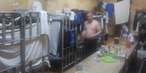 Ein nicht zu erkennender Mann durchschreitet einen Schlafsaal in der Arbeitskolonie LIU-19 im russischen Mordwinien.