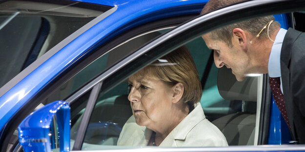 Angela Merkel in einem Volkswagen mit VW-Markenvorstand Herbert Diess
