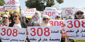 Demonstrantinnen halten Plakate hoch, auf denen unter anderem auf arabisch steht: „Artikel 308 schützt nicht die Ehre, sondern den Täter“