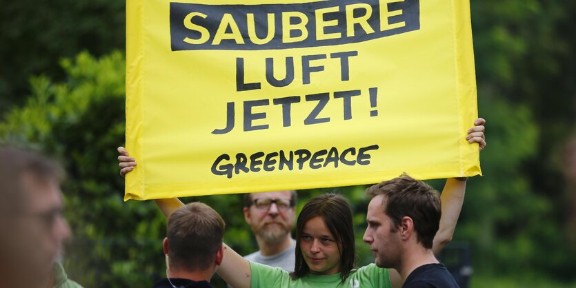 Eine Frau hält ein Plakat hoch