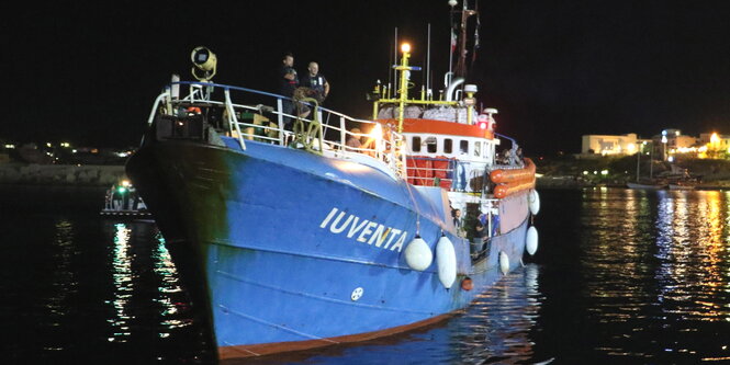 ein Schiff bei Nacht in einem Hafenbecken