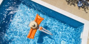 Eine Frau mit Luftmatratze in einem Pool