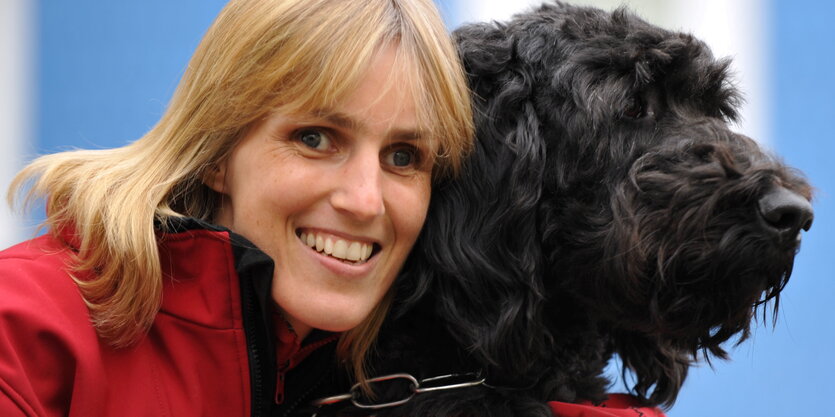 Ein blonde Frau mit einem schwarzen Hund