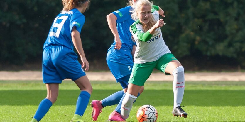 Drei Mädchen in einem Fußballspiel