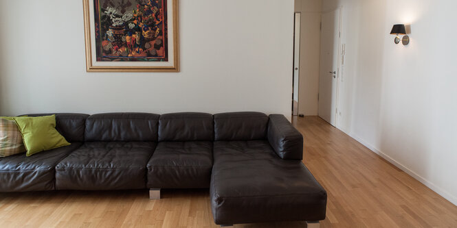 Eine schwarze Couch steht in einem Wohnzimmer