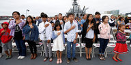 Kinder legen ihre rechte Hand aufs Herz bei einer Einbürgerungszeremonie