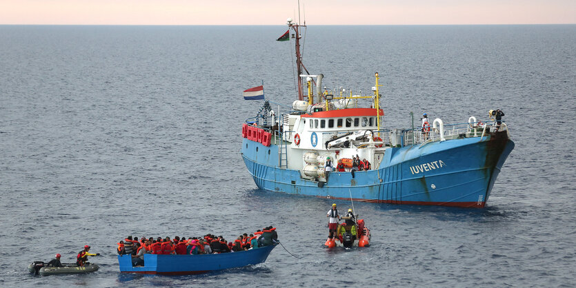 Ein blaues Holzboot neben einem blauen Schiff