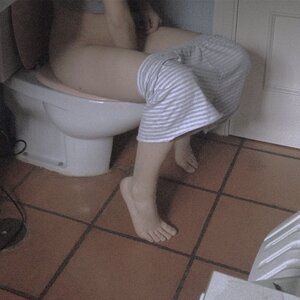 Eine Frau sitzt auf der Toilette