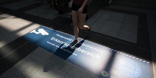 Bodenaufkleber weisen im Bahnhof Südkreuz in Berlin auf Erkennungsbereiche zur Gesichtserkennung hin