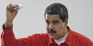 Maduro hält einen gefalteten Wahlzettel in der Hand