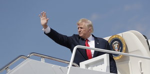 Trump winkend an der Gangway zu einem Flugzeug