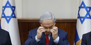 Benjamin Netanjahu nimmt sich eine Brille ab