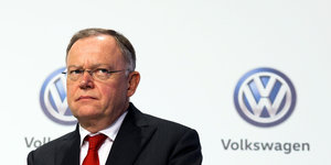 Stephan Weil neben einem VW-Logo