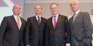 Vier Männer im grauen Anzug