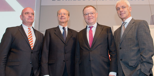Vier Männer im grauen Anzug