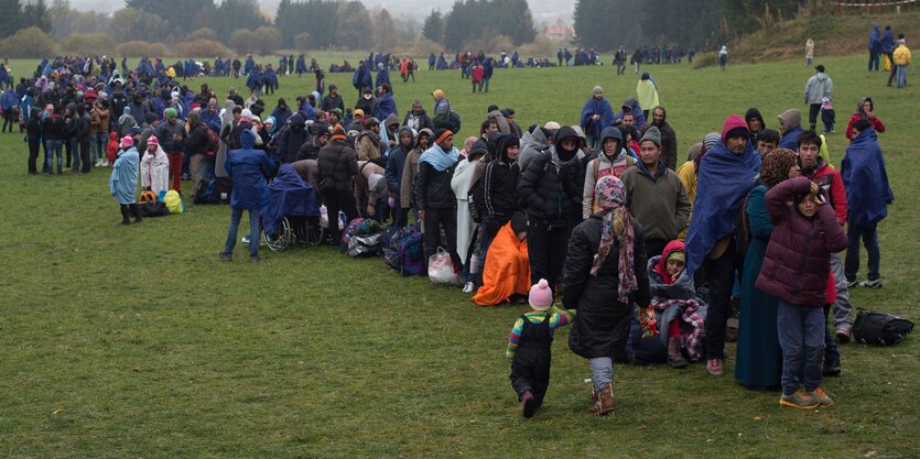 Eine größere Menschenmenge warten auf einer Wiese