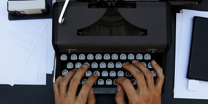 Hände tippen auf einer Schreibmaschine