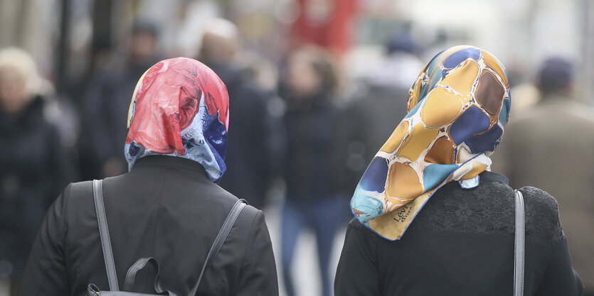 Zwei frauen mit Kopftuch auf einem Gehweg