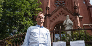 Stefan Liebich steht vor der Gethsemanekirche im Prenzlauer Berg