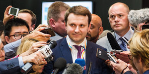 Journalisten halten Mikrofone vor einen G20-Gipfelteilnehmer