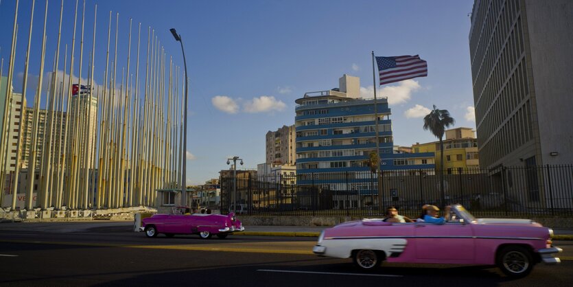 Autos vor einem Gebäude, auf dem die US-Flagge weht