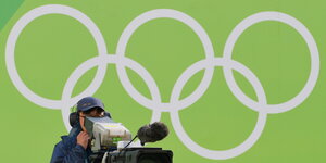ein Kameramann vor Olympischen Ringen