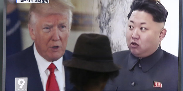 Donald Trump und Kim Jong Un auf einem Fernsehbildschirm