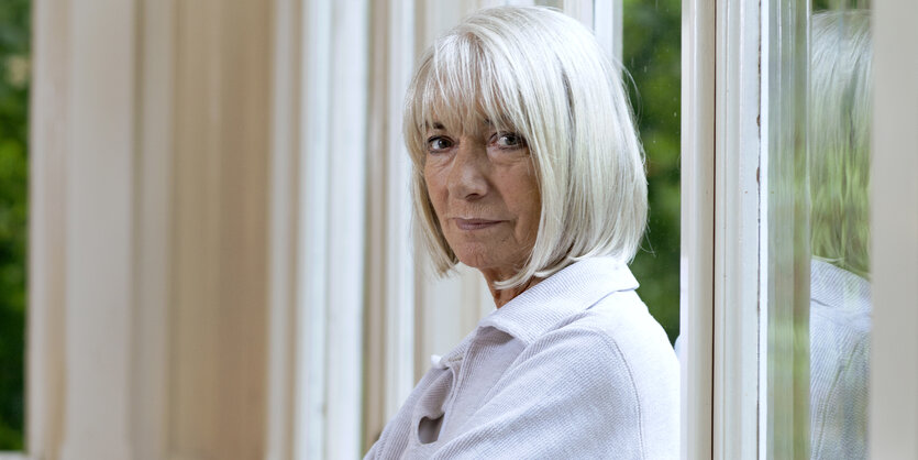 Eine Frau in einem weißen Pullover mit fast genauso weißen, kinnlangen Haaren