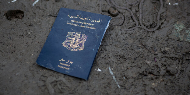 Ein syrischer Pass liegt im Dreck.