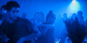 Menschen tanzen in blauem Licht