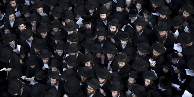 Zahlreiche Ultraorthodoxe mit Hüten und in schwarzer Kleidung