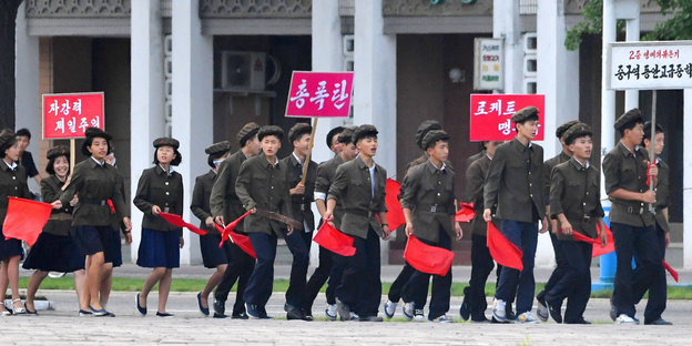 Schüler in Pjöngjan zeigen mit roten Fahnen ihre Unterstützung für das Regime