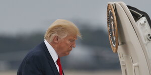 US-Präsident Donald Trump steht mit gesenktem Kopf auf der Andrews Air Force Base