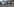 Große Autos stehen in der Straße, keine Menschen sind zu sehen, dunkle Wolken