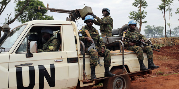 Bewaffnete Uniformierte auf einem weißen Pickup-Truck mit dem Aufdruck „UN“