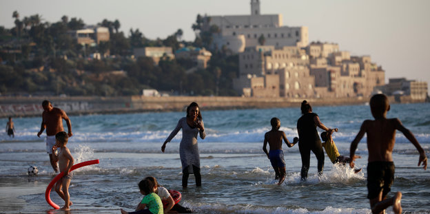 Menschen lachen am Strand von Tel Aviv
