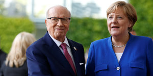 Ein Mann drückt die Hand einer Frau. Es ist die von Bundeskanzlerin Angela Merkel