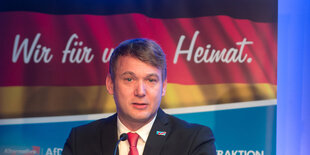 AfD-Politiker Poggenburg steht vor einem AfD-Plakat