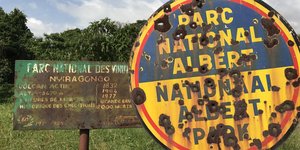 Ein Eingangsschild am Virunga-Nationalpark im Kongo voller Einschusslöcher