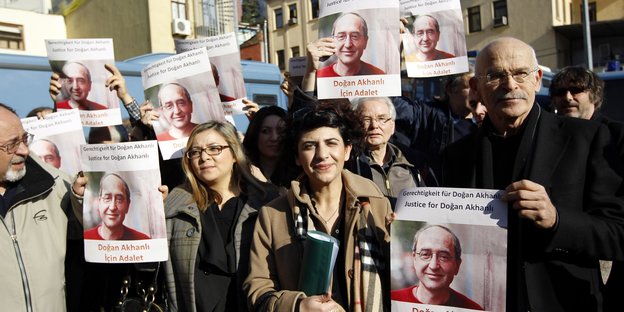 Menschen halten Poster, auf denen das Gesicht Doğan Akhanlıs zu sehen ist, in die Höhe