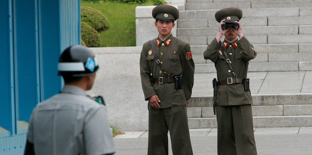 Nordkoreanische Soldaten beobachten durch ein Fernglas einen südkoreanischen Soldaten