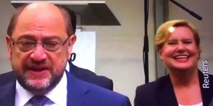 Martin Schulz im Vordergrund guckt betroffen, Eva Högl im Hintergrund lacht