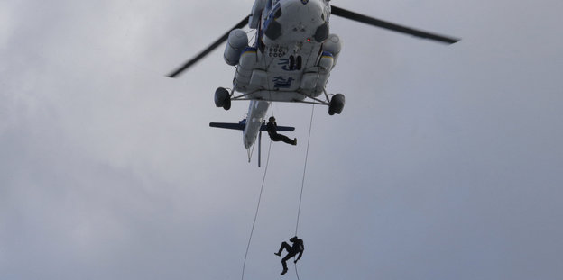 Ein südkoreanischer Polizist seilt sich aus einem Helikopter ab