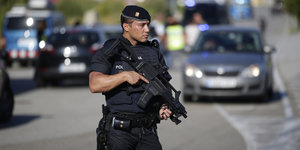 Ein spanischer Polizist hält seine Waffe nah bei sich