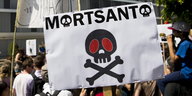 auf einem Plakat steht „Mortsanto“, die „Os“ sind als Totenkopf dargestellt, darunter ein großer Totenkopf