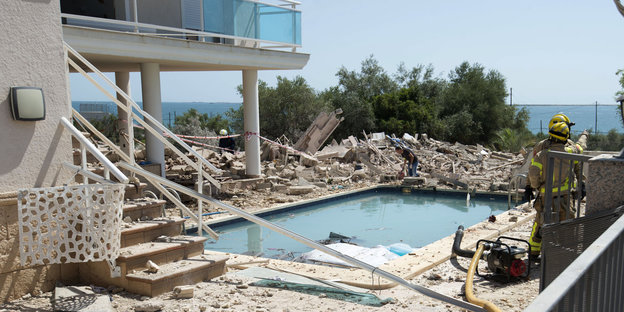 ein Haus, ein Swimmingpool und viele Trümmer