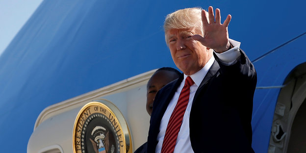 Trump steht vor der Airforce One und winkt - aber mit der linken Hand