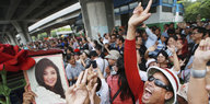 Yingluck Shinawatras Anhänger demonstrieren vor Gericht und halten ein Foto der Frau in den Händen